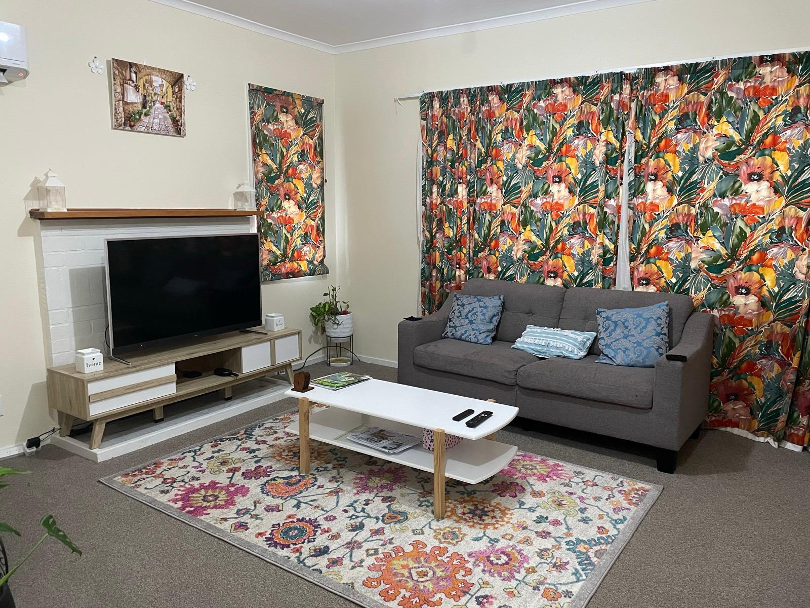 Living room with tropical floral curtains and patterned rug