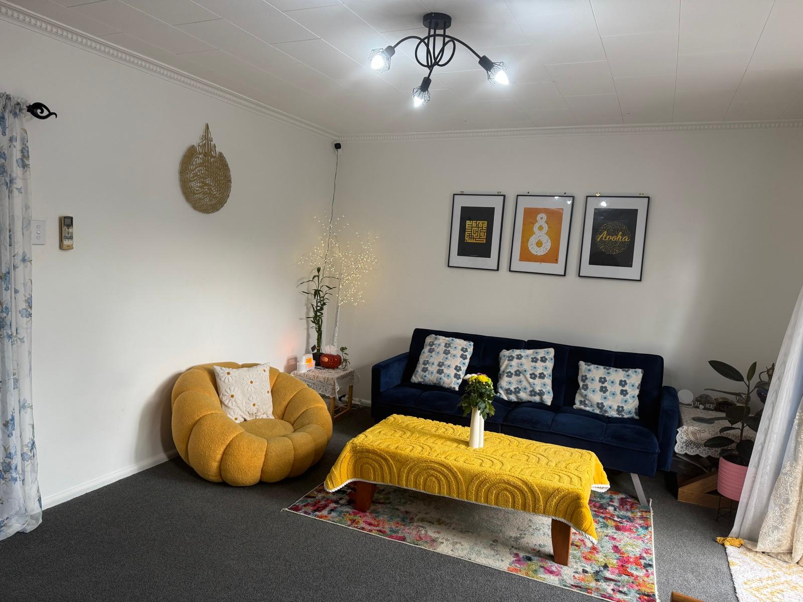 Navy velvet sofa and mustard armchair with multicultural wall prints